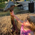 Child touching giraffe monument