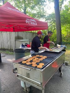 Outback Steakhouse employees cooking on the grill.